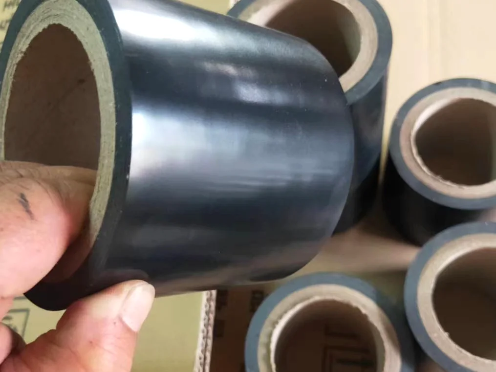 Real smooth black PVC pipe wrap tape roll held above carton packing